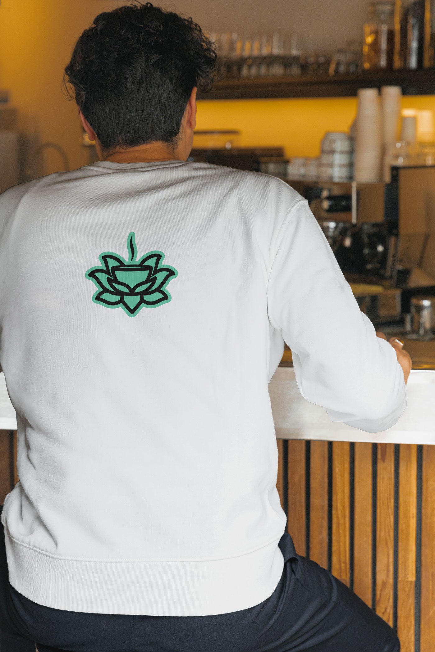 Man with a white long sleeve shirt and Flowstate logo in the middle