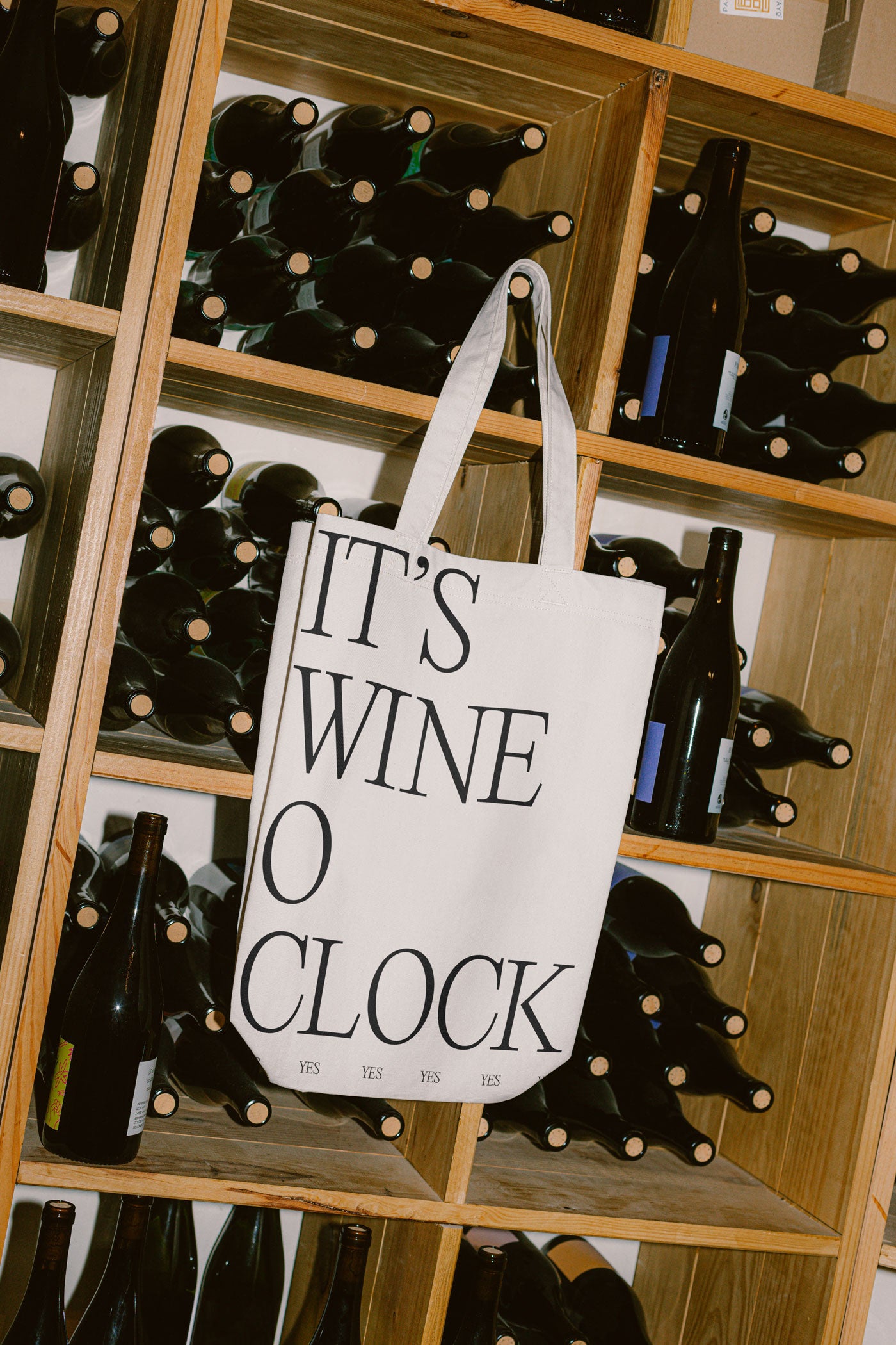 Tote bag in a wine cellar that says "It's wine o clock"