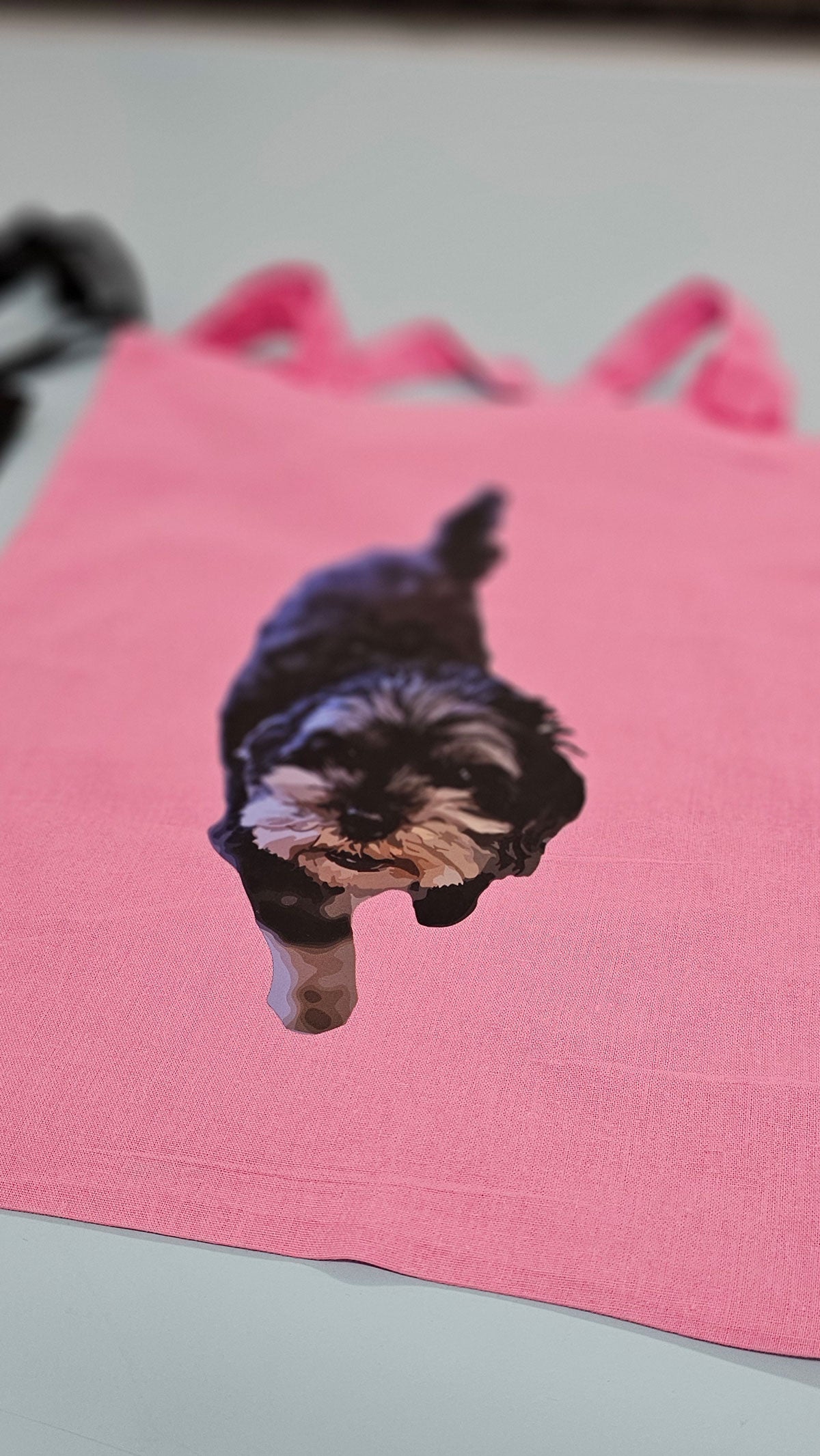 A pink tote bag with a DTF transfer of a dog on it