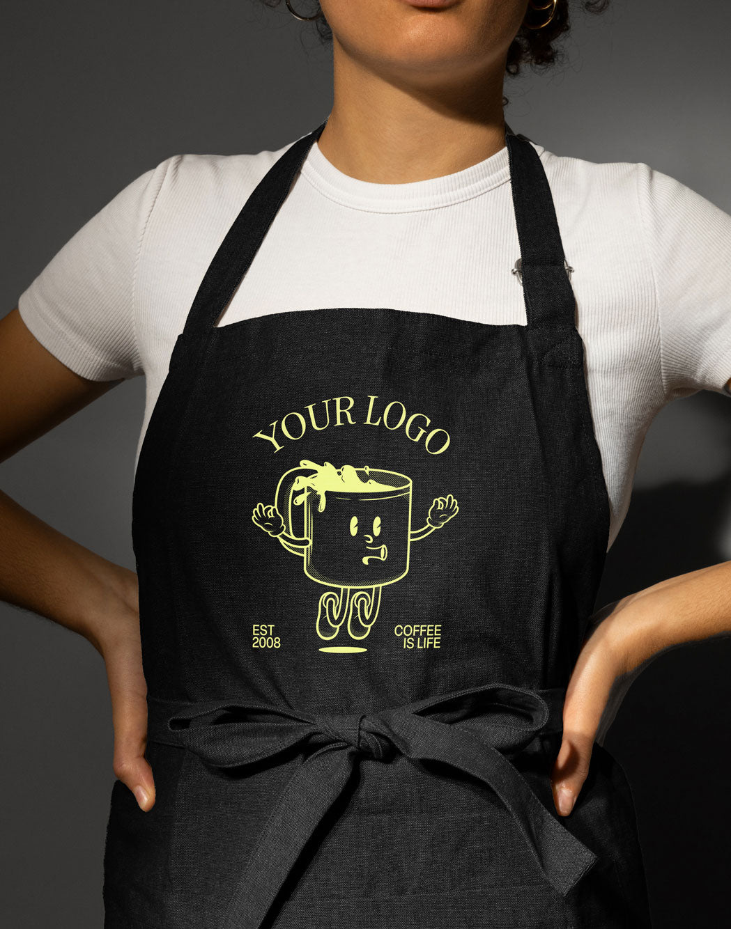 Woman wearing an apron with a DTF transfer image of a coffee cup on it that says "your logo here"